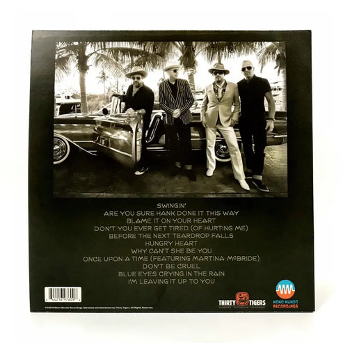Back cover of a music album featuring a black and white photograph of four men posing next to a vintage car, with a track listing below.