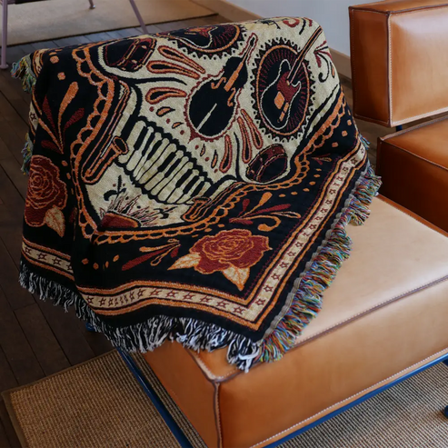 Woven blanket with musical instrument and rose designs.