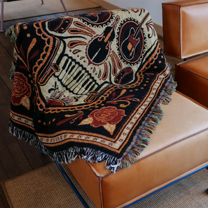 Woven blanket with musical instrument and rose designs.