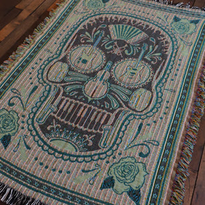 Woven skull blanket with musical instruments.