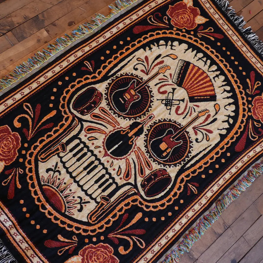 Woven skull blanket with musical instruments.